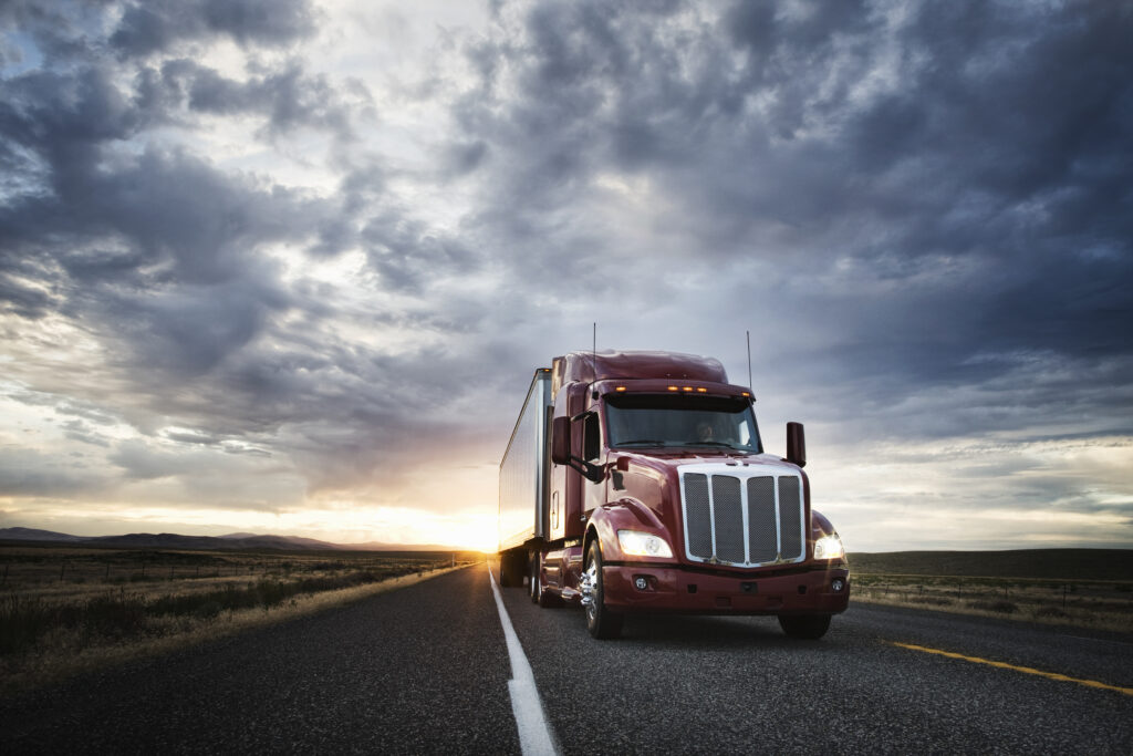 3/4 front view of a commercial truck on the road at sunset in eastern Washington, USA